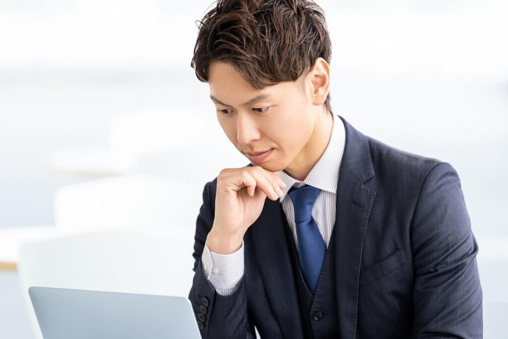 パソコンを見て考えるビジネスマン