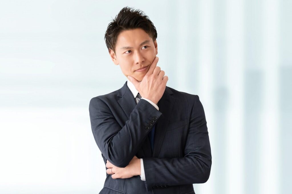 腕を組んで考えるビジネスマン