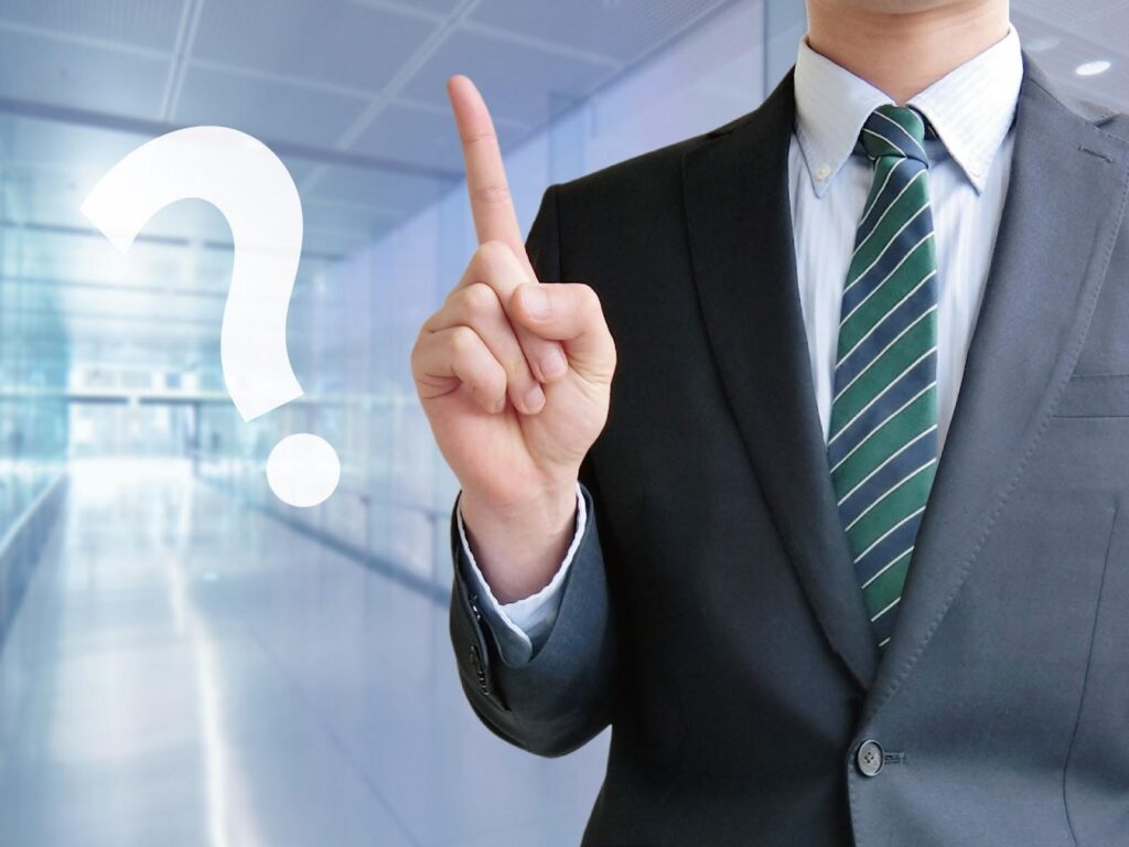 人差し指を立てて解説する男性とはてなマーク
