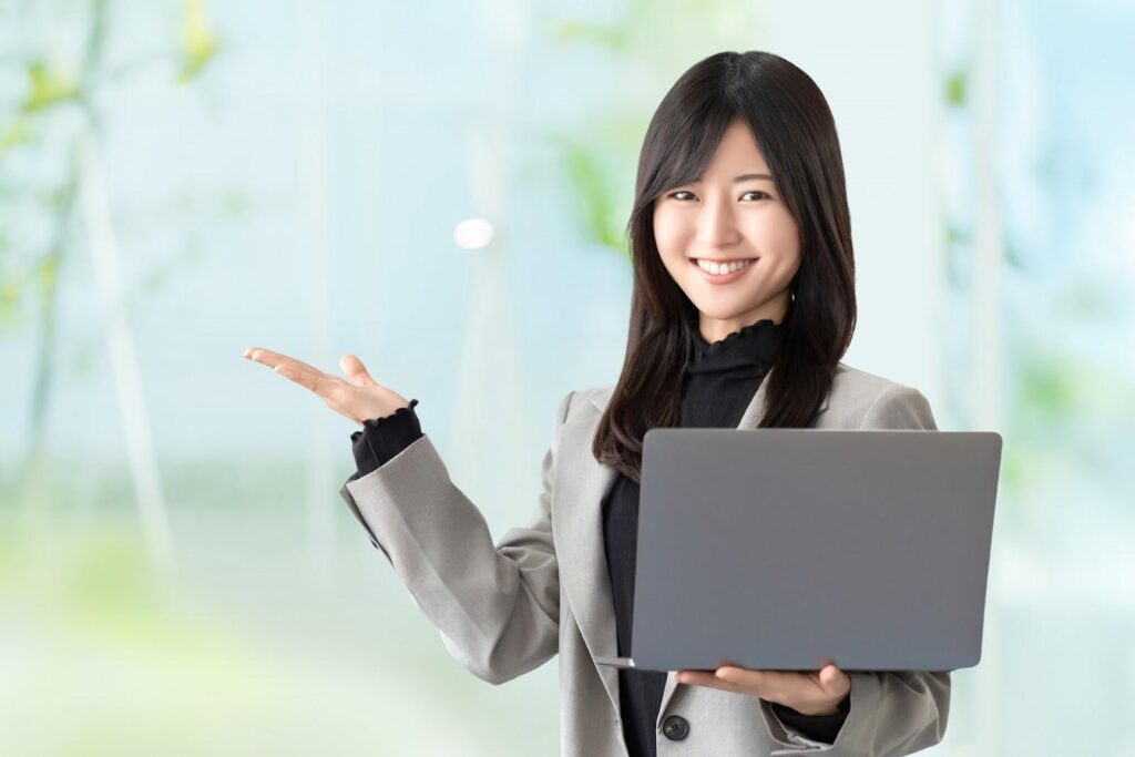 パソコンを持って微笑む女性