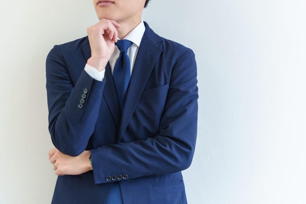 考えている青スーツの男性