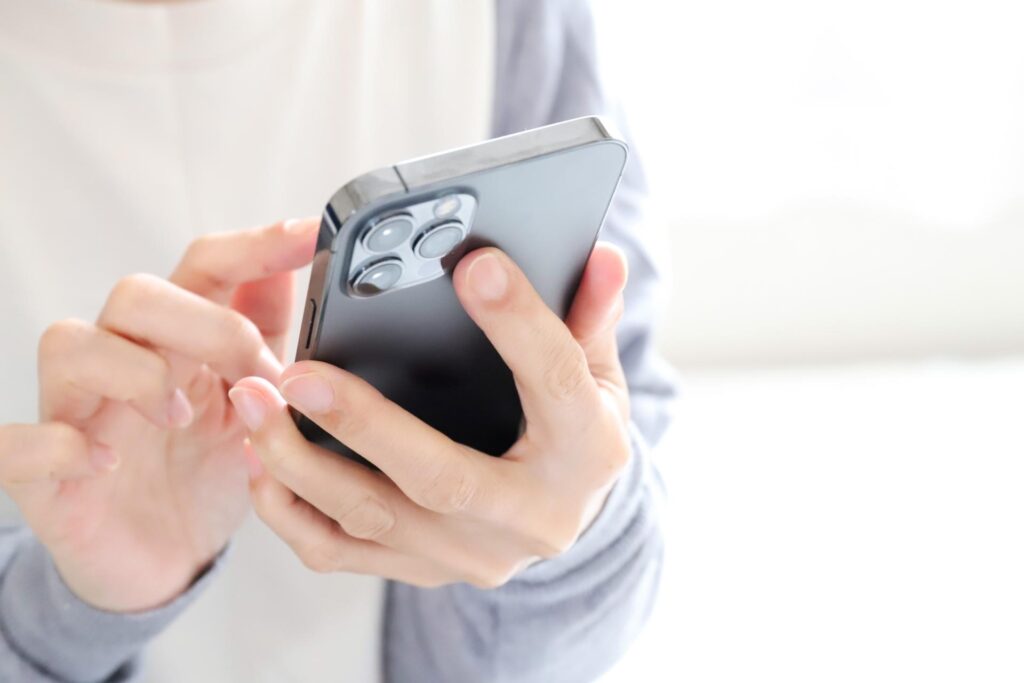 スマートフォンを操作する人の手元