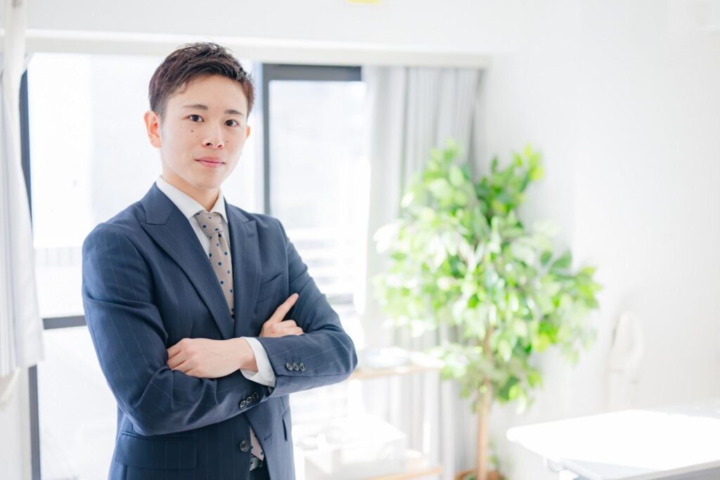 移動平均線の期間設定について腕を組んで考えるビジネスマン