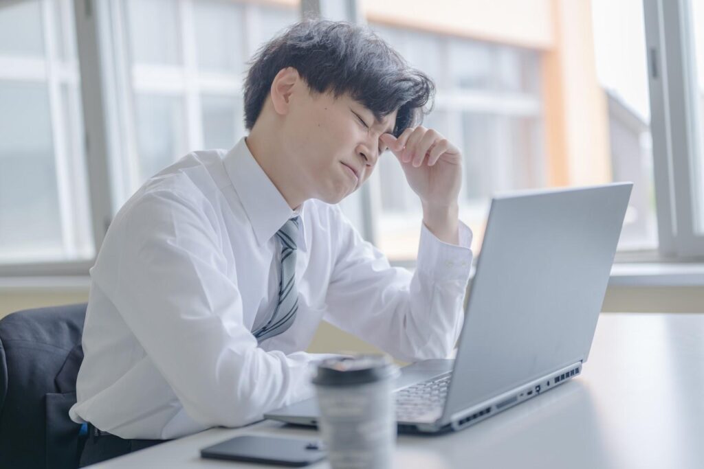FXで負けて頭を悩ませる白スーツの男性