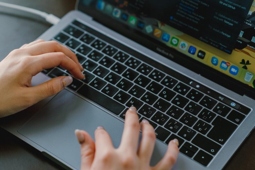 ほかのテクニカル指標の組み合わせについてMacパソコンで調べている女性の手元