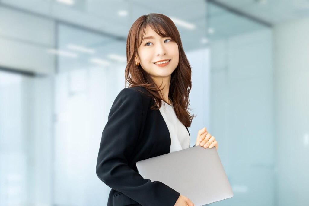 ファインダーを片手に持って遠くを眺める女性