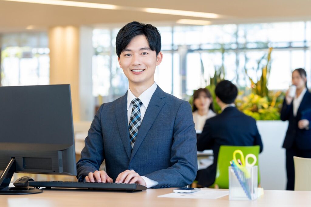 おすすめのトレードスタイルについて解説するスーツ姿の爽やかな男性
