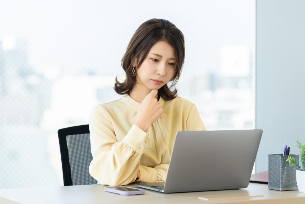 FXのスリッページで注意したいポイントについてパソコンを見ながら考えている女性