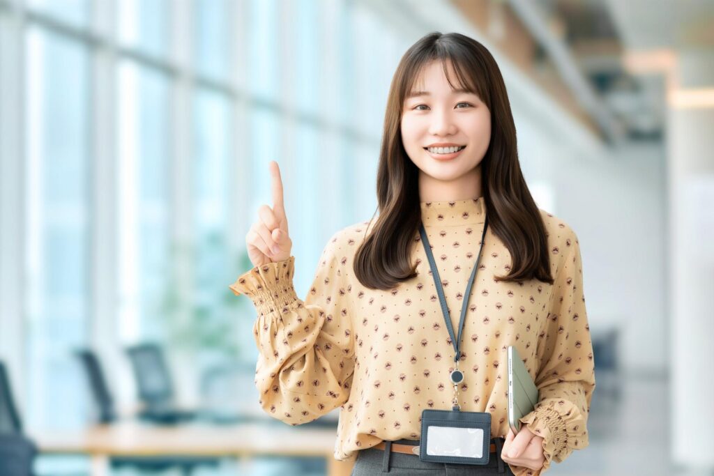 人差し指を立ててこちらに微笑む社員女性