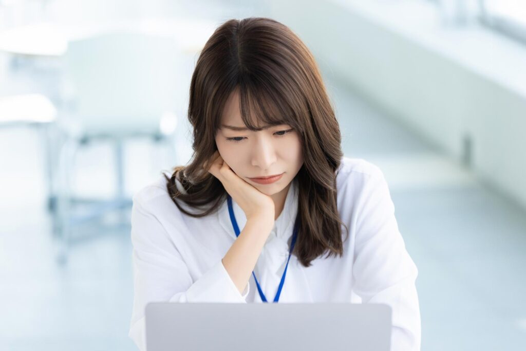 FXで勝率が下がりパソコンの前で悩んでいる女性