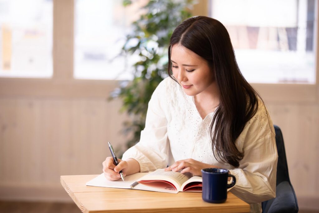 カフェで勉強しているロングヘアの女性