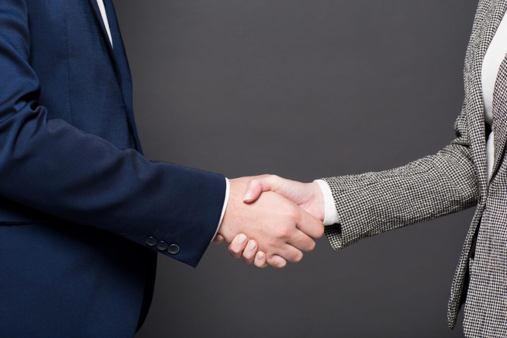 2人のスーツ姿の男性が握手している
