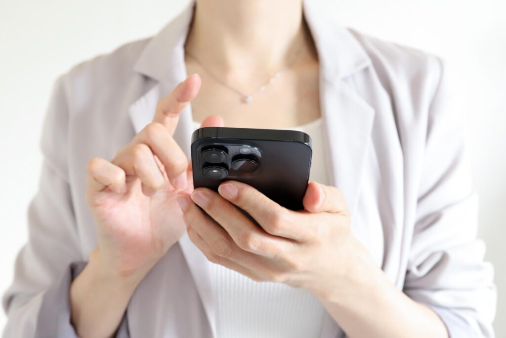 FX取引アプリをスマホで操作する女性