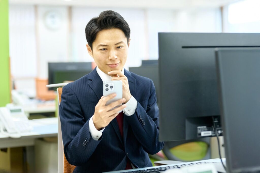 スマホでFX取引のメリットを確認するビジネスマン