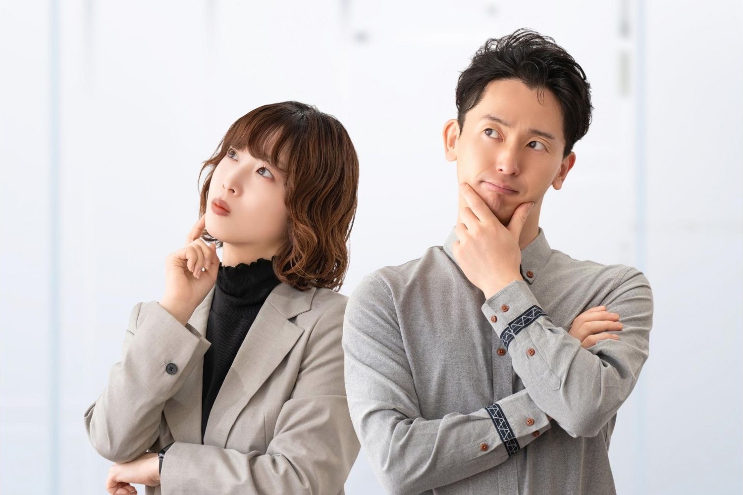 腕を組み、同じ方向を見ながら考える男女