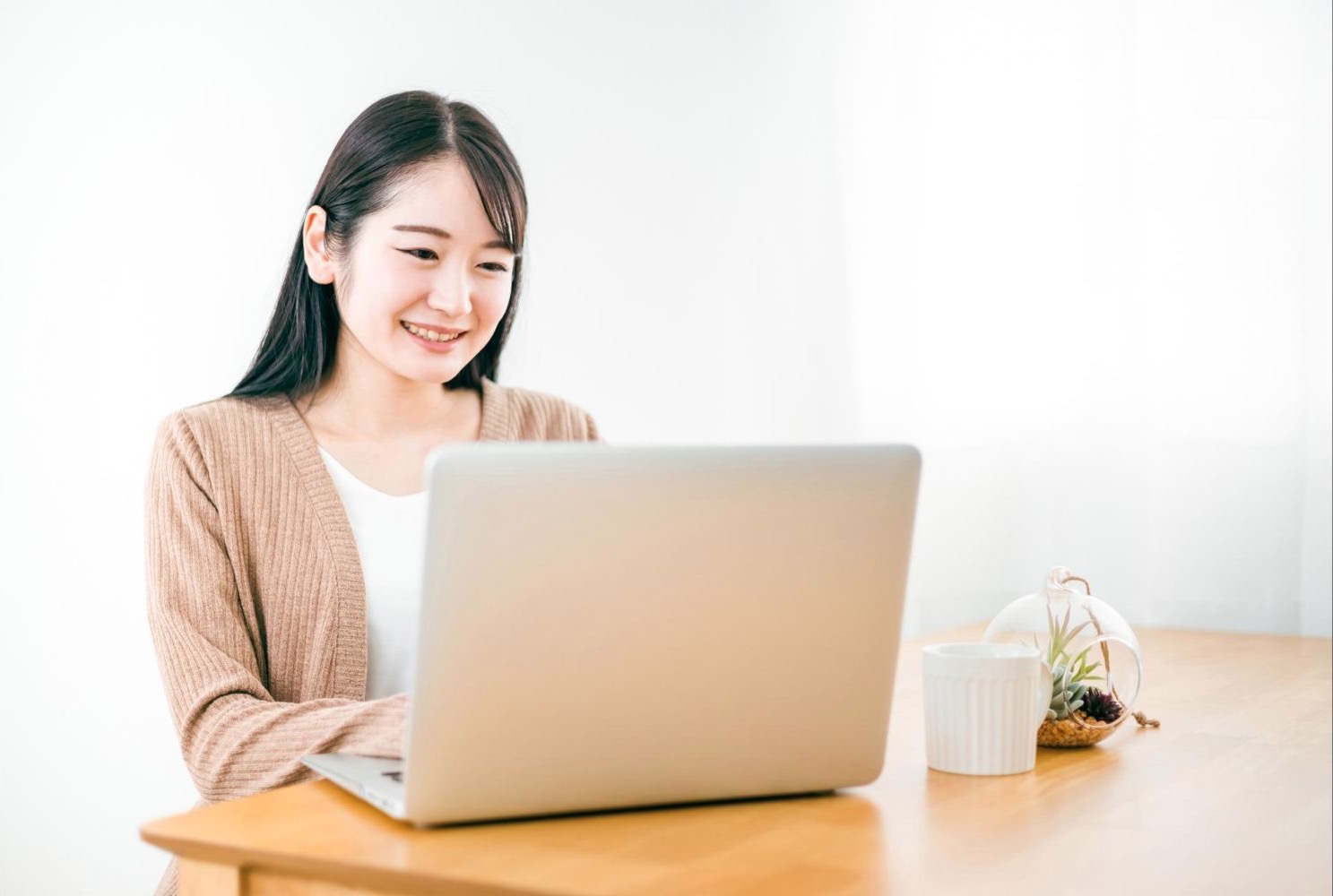 明るい部屋でノートパソコンを使う女性