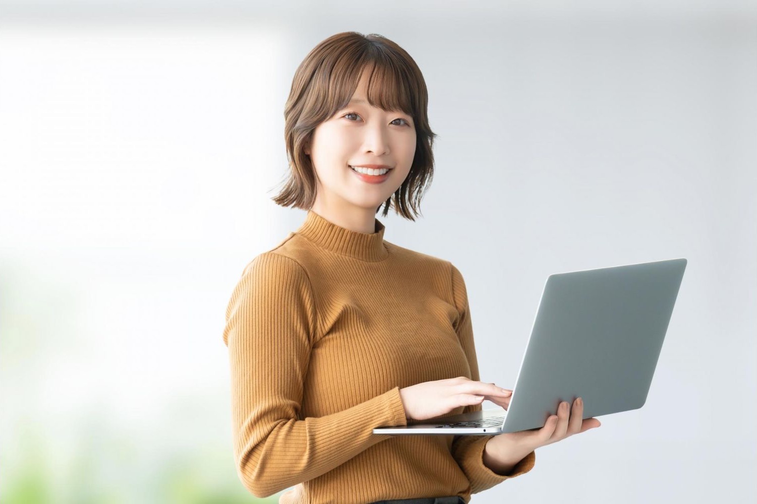 ノートパソコンを開いて説明する女性