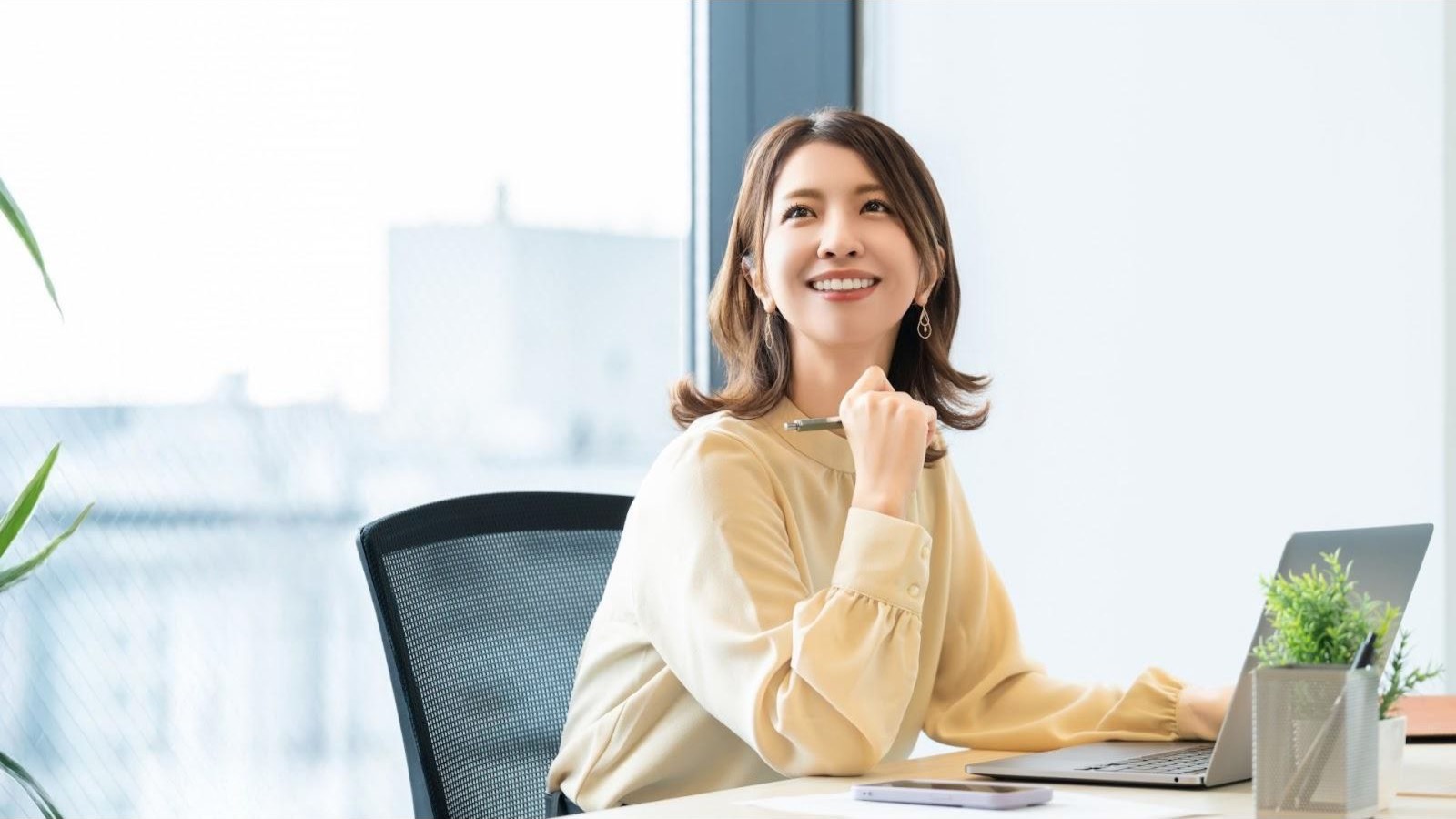 オフィスの机で笑顔を見せる女性