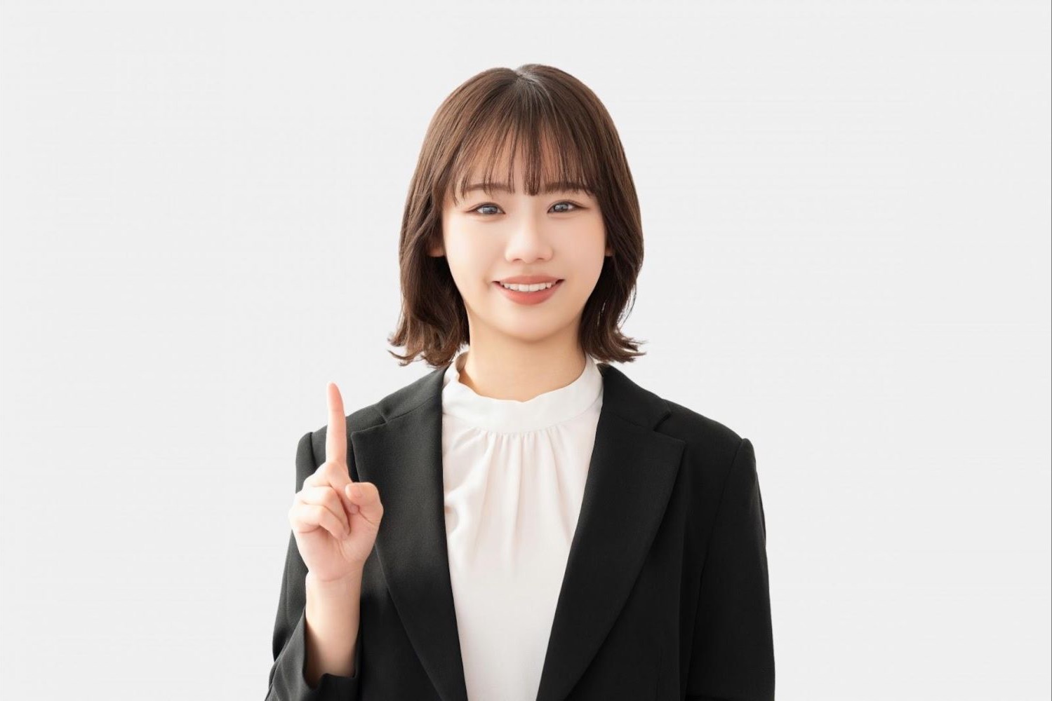人差し指を立てて説明する女性会社員