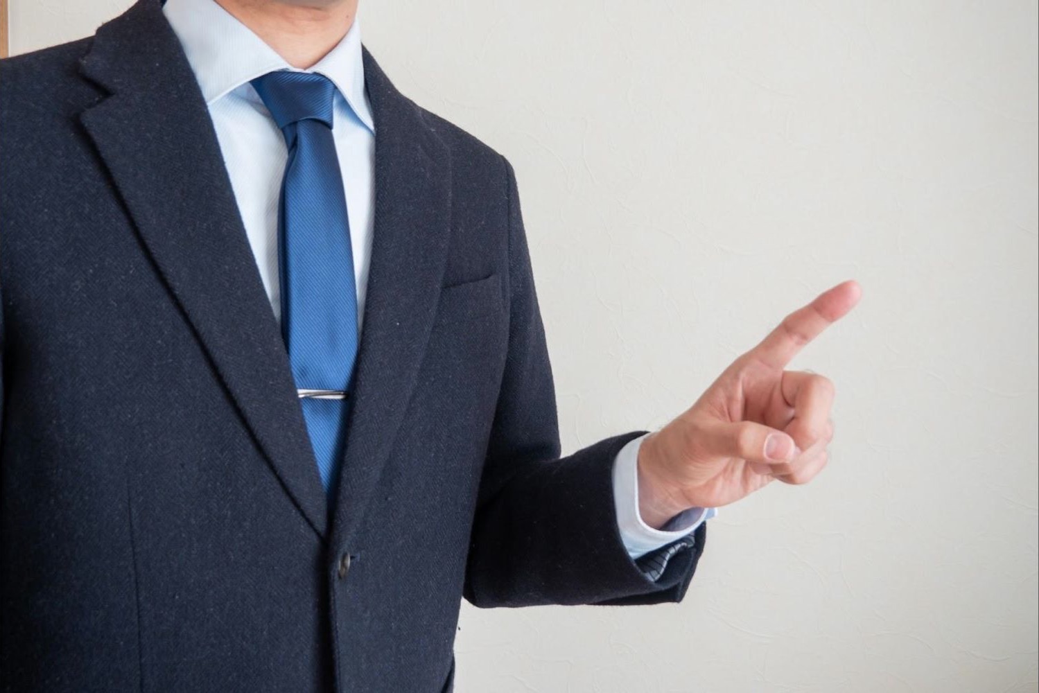スーツ姿で人差し指を立てて説明する男性