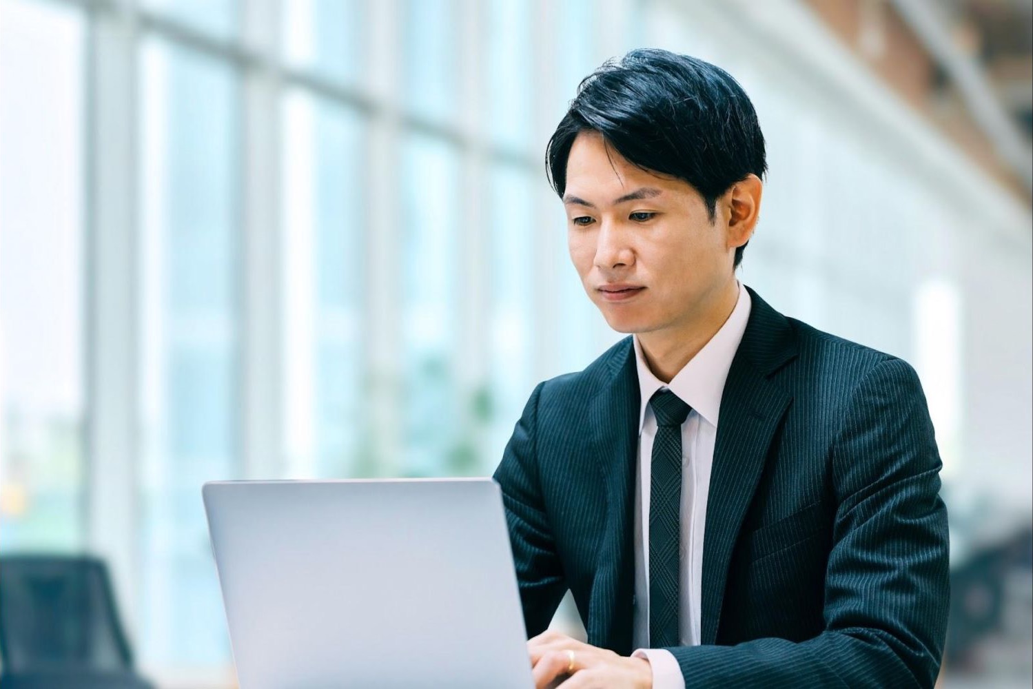 オフィスでノートパソコンを操作する男性会社員