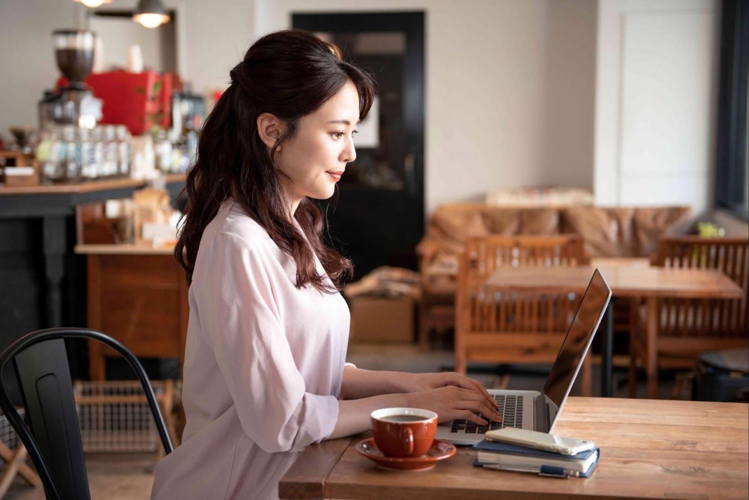 カフェの席でノートパソコンを操作する女性
