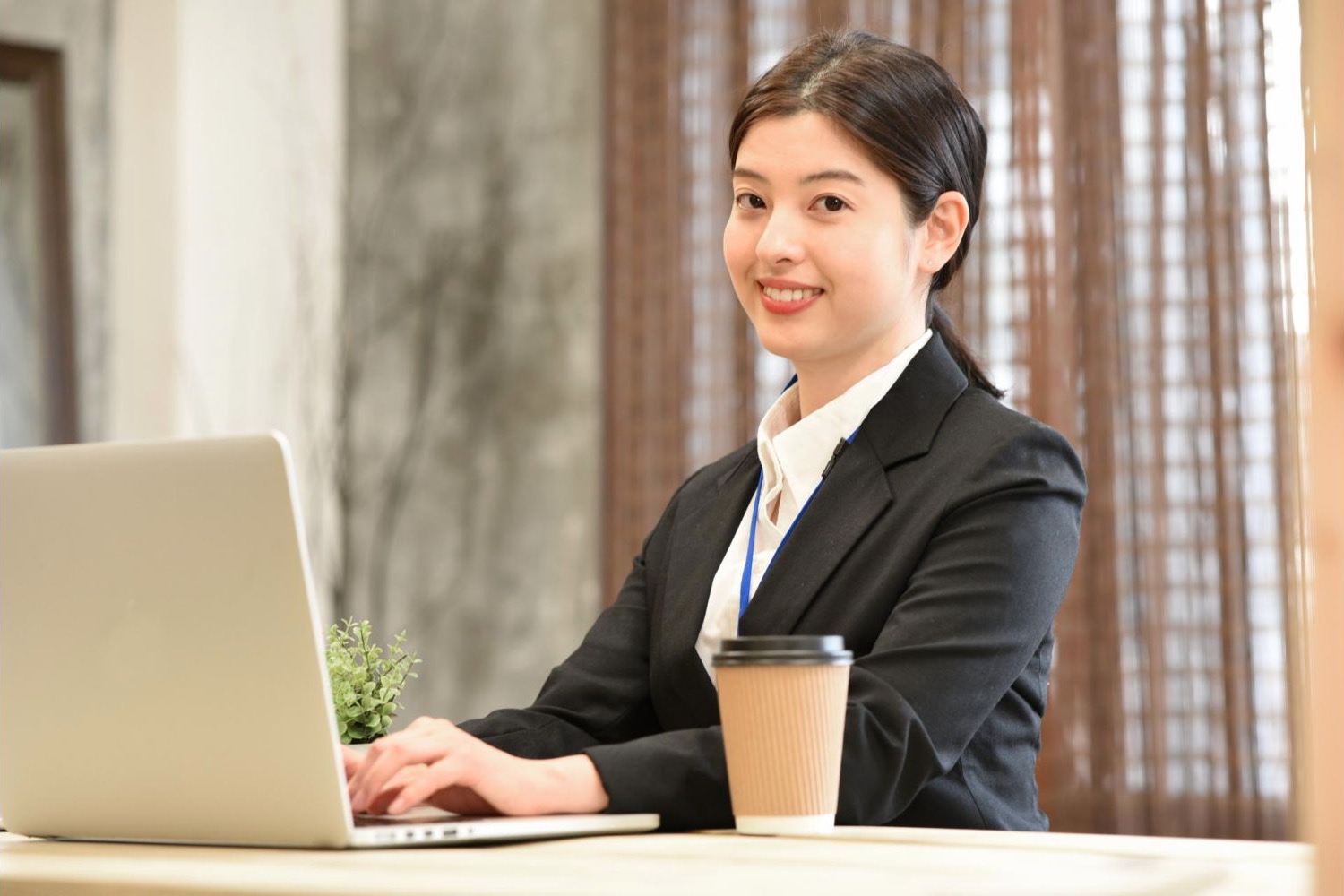 カフェでノートパソコンを操作する女性会社員