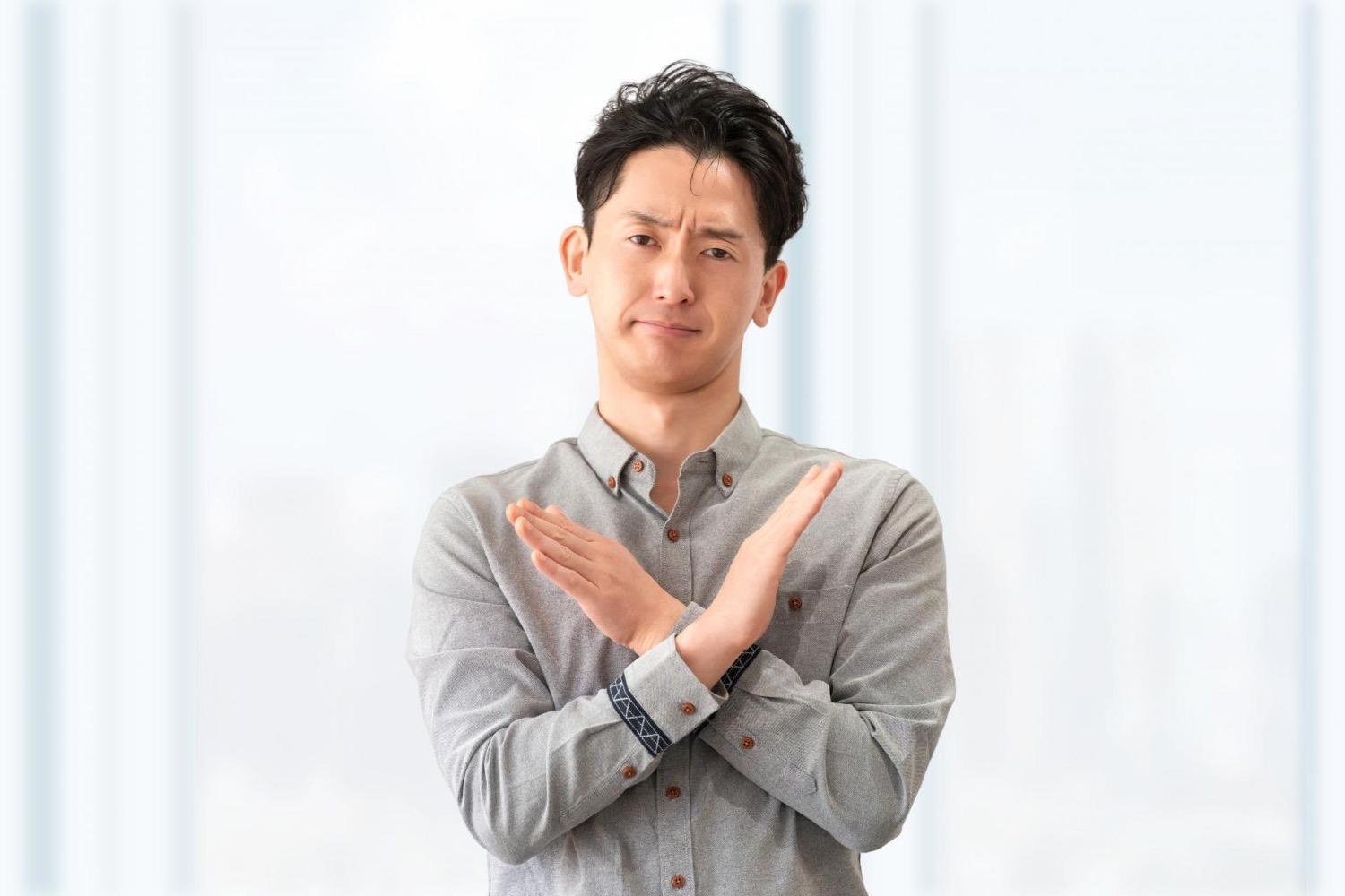 胸の前で両腕を交差する男性