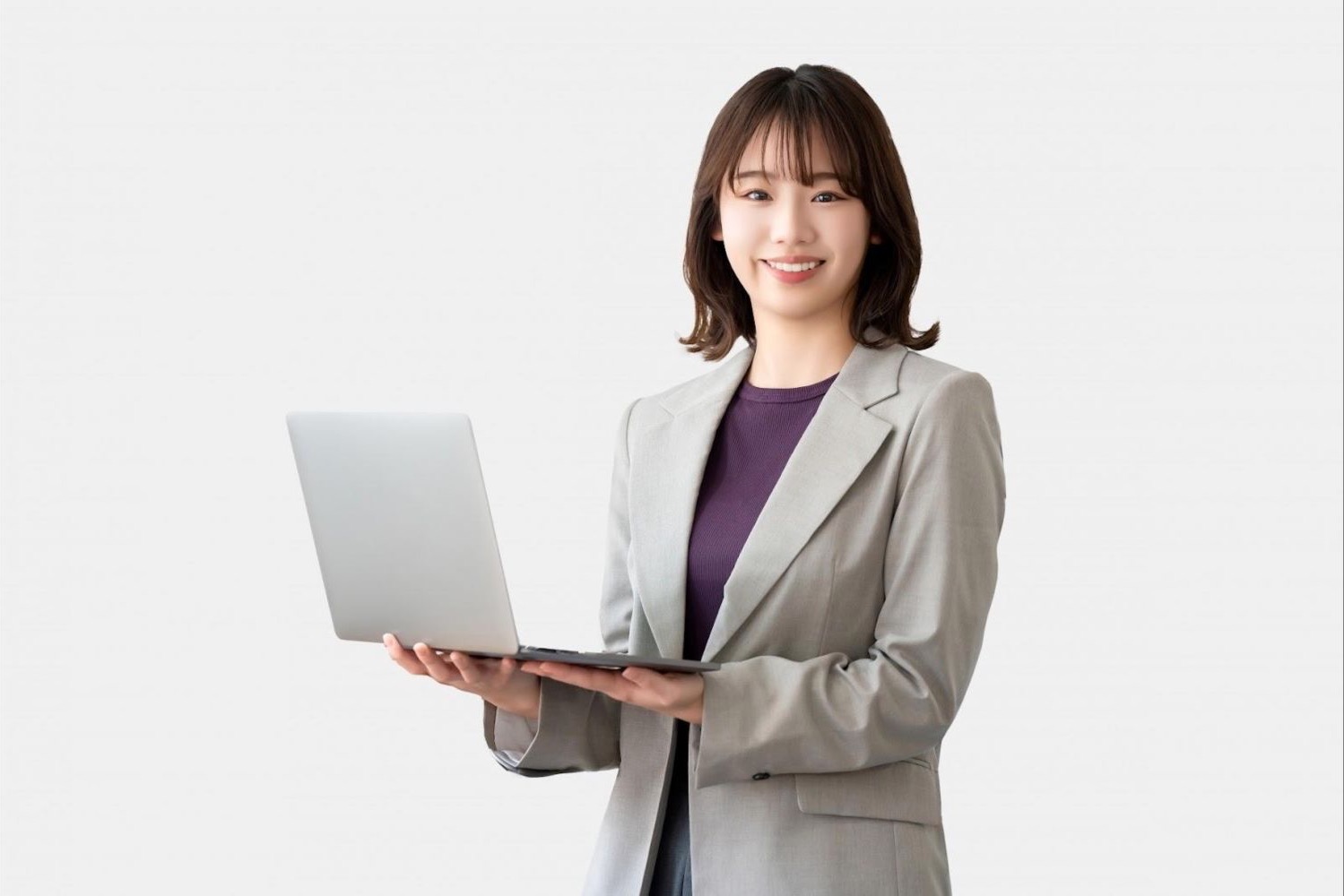 ノートパソコンを持って立つ女性会社員