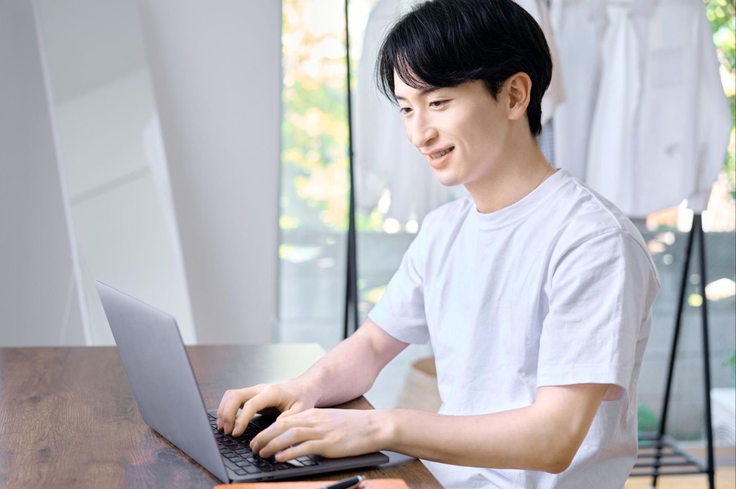 自宅の机でノートパソコンを使う男性