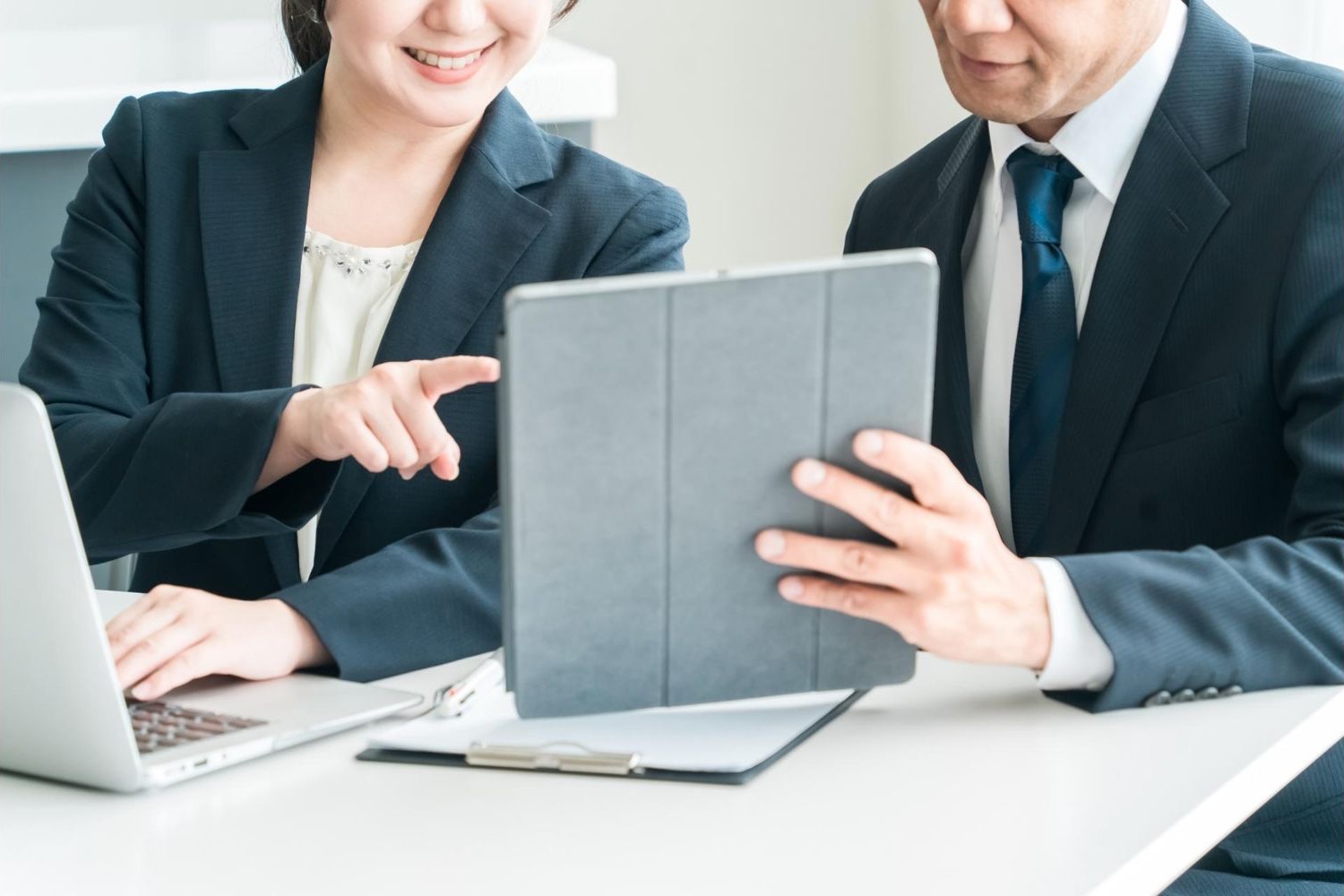 タブレットの画面を見ながら打ち合わせる男女