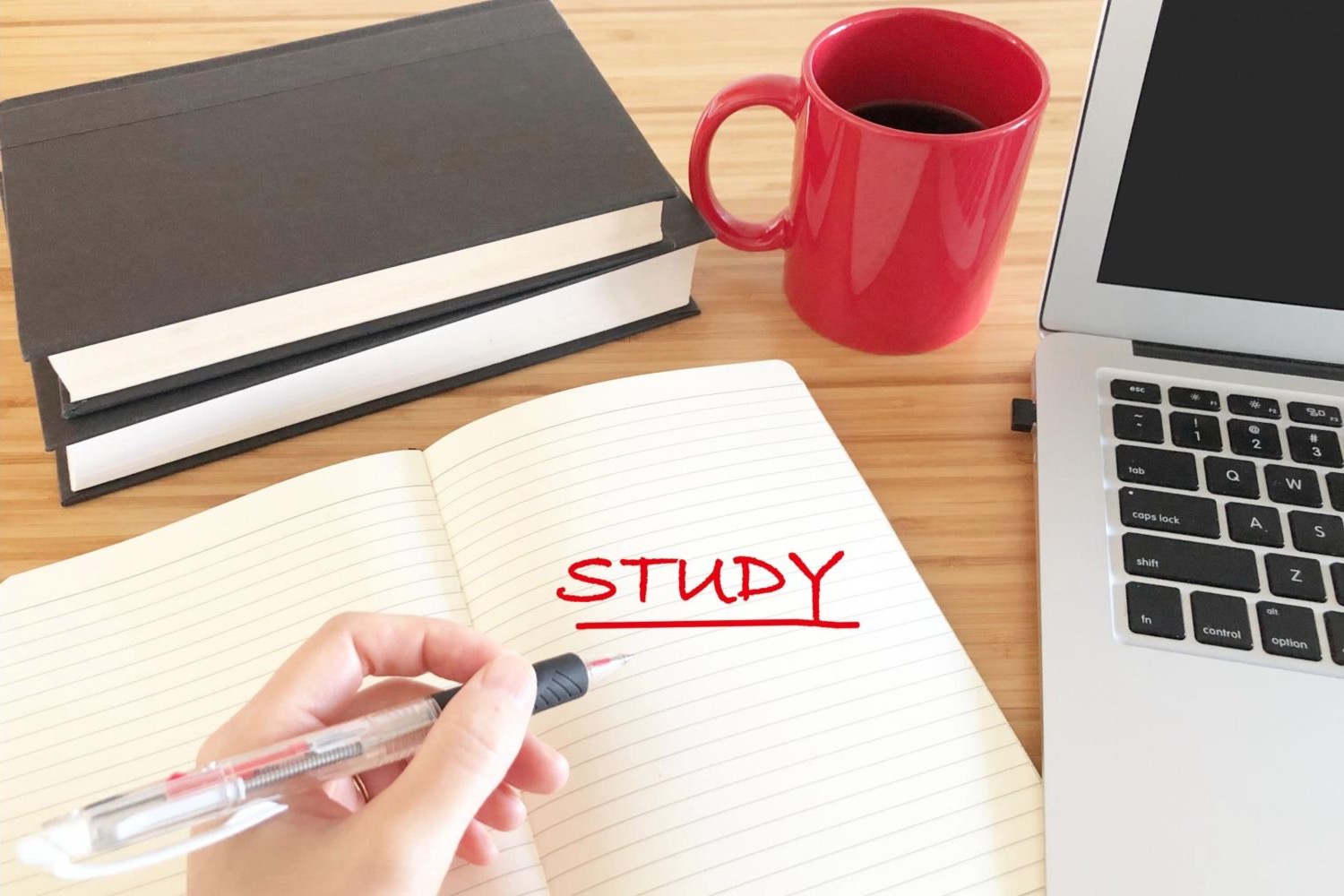 ノートにSTUDYと書き、学習計画を立てる手元