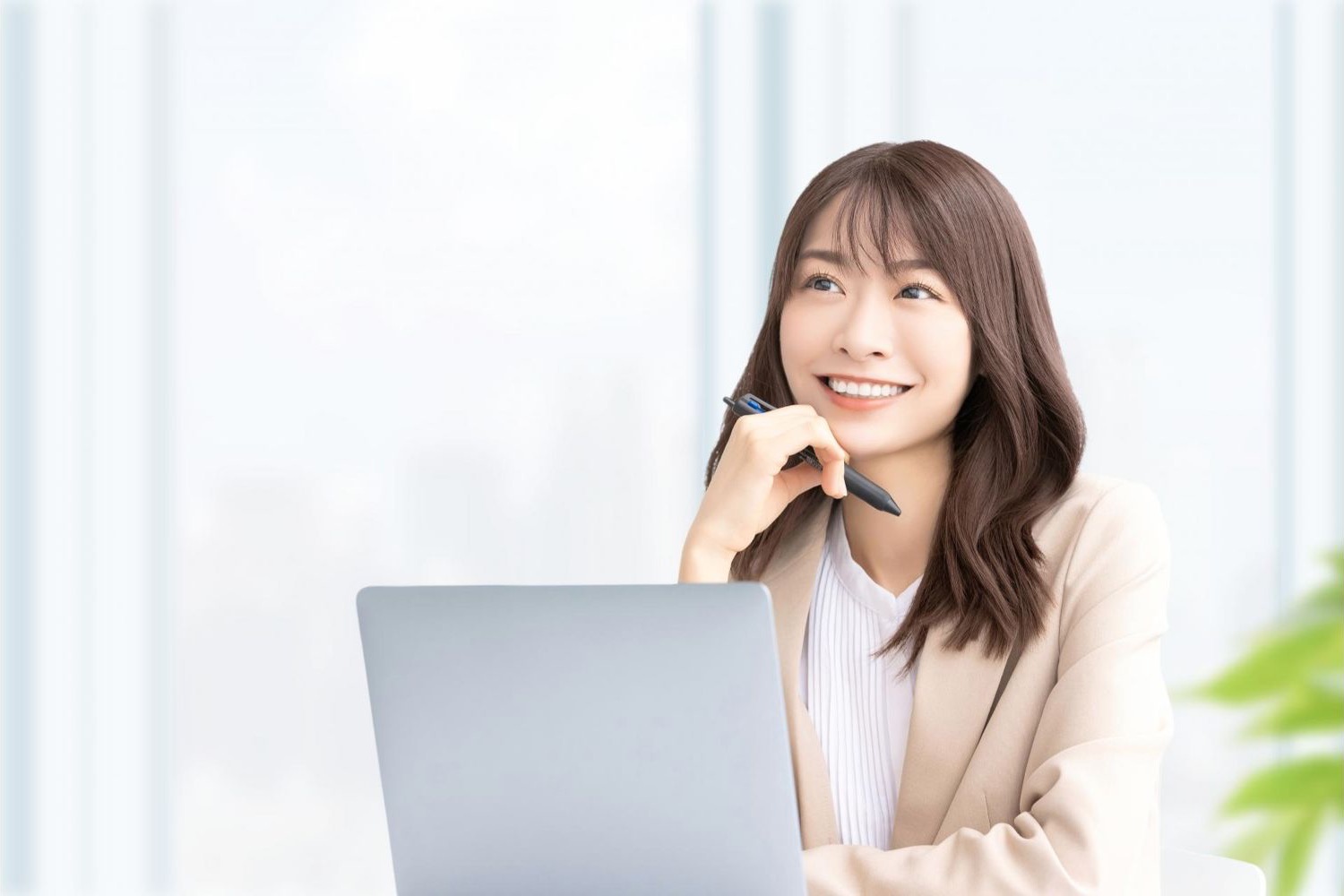 ノートパソコンの前で笑顔を見せる女性