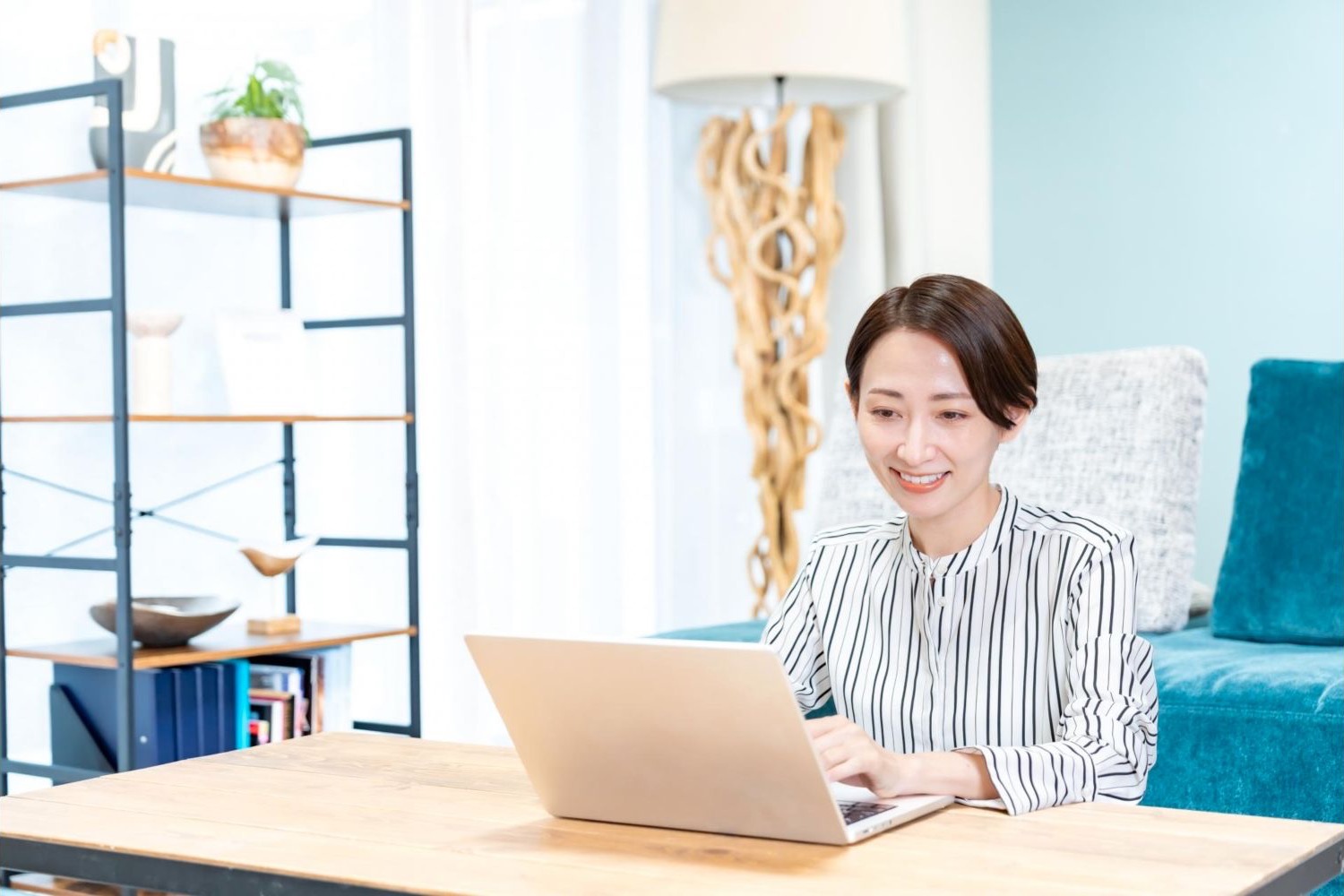 自宅の机でノートパソコンを操作する女性