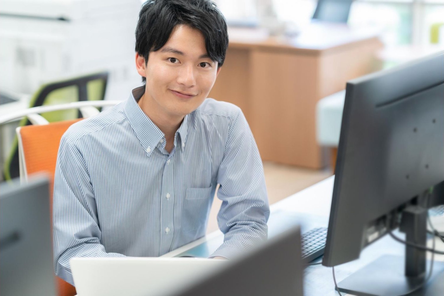 デスクトップパソコンの前に座る男性会社員