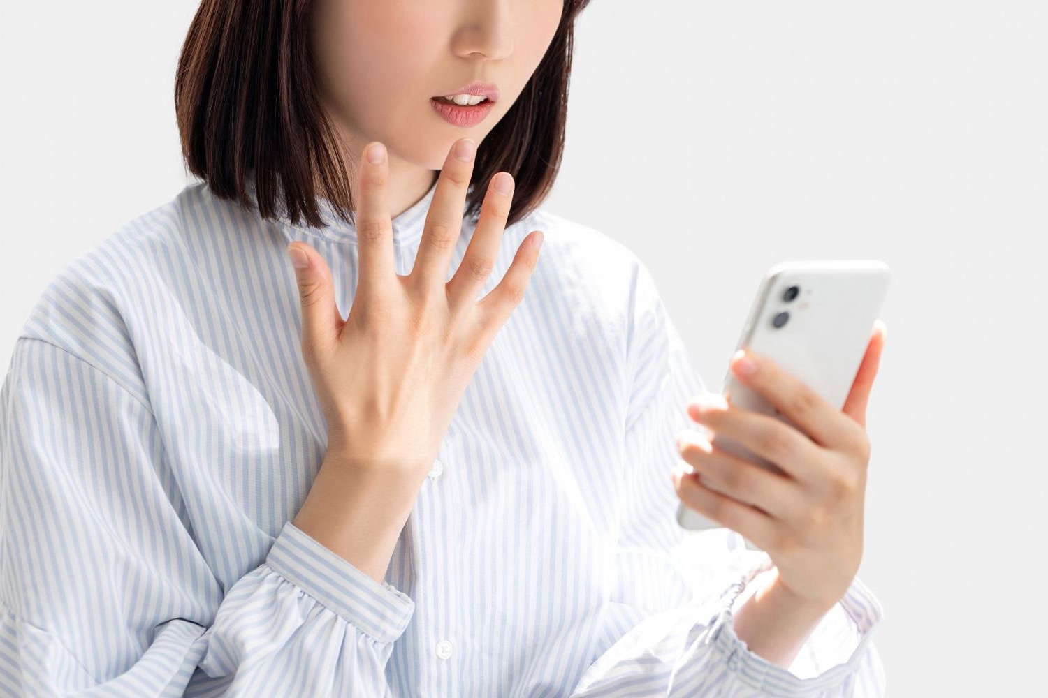 スマートフォンを見て驚く女性