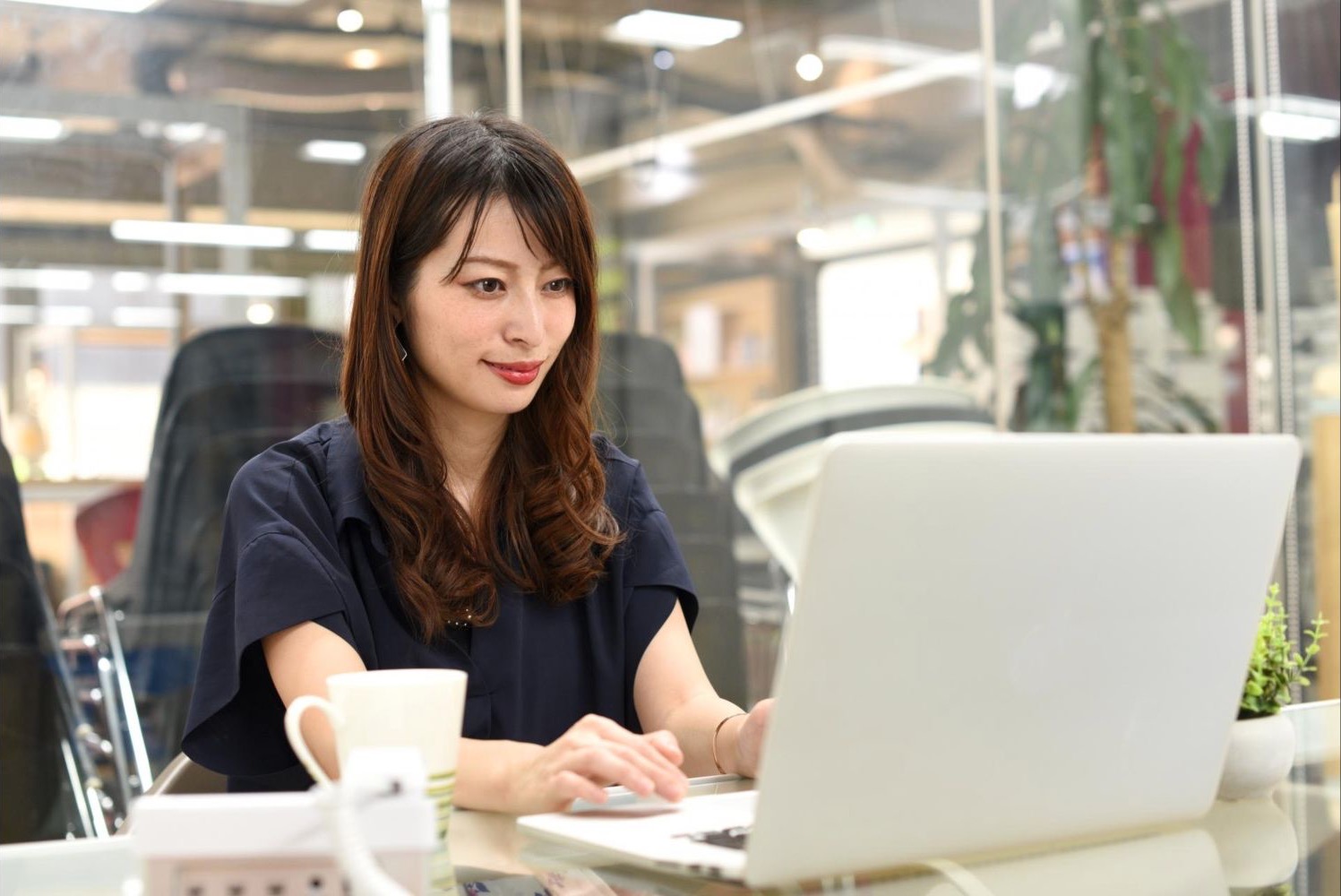 カフェでノートパソコンを操作する女性