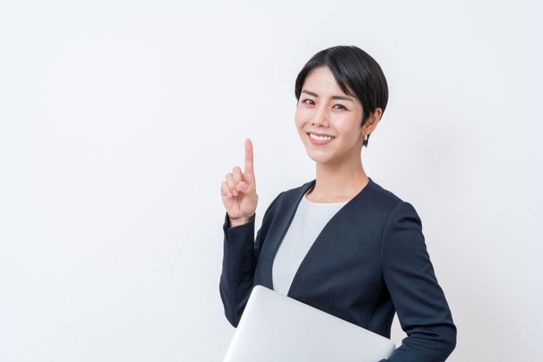 書類を持ち、人差し指を立てる女性会社員