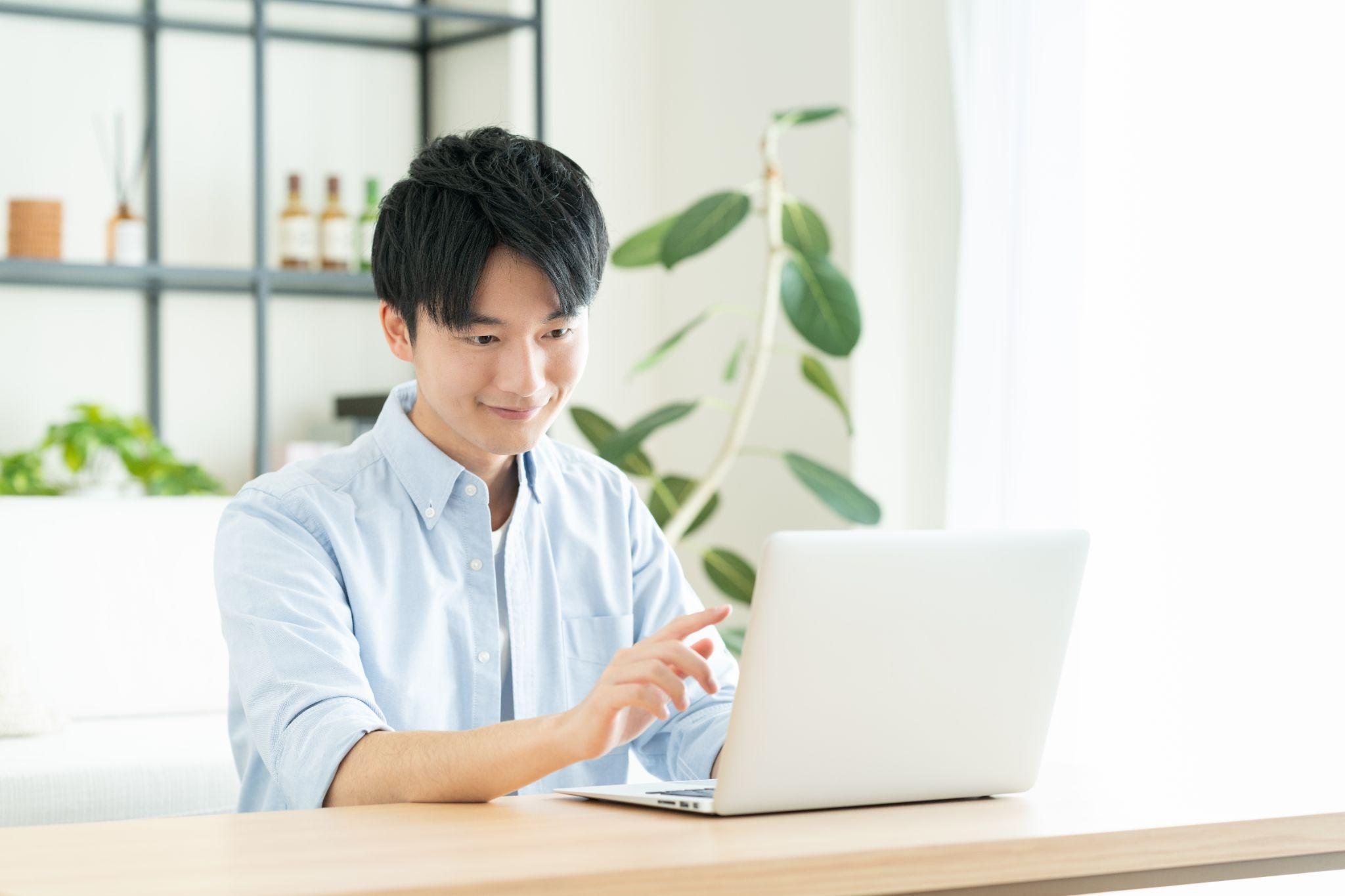 リビングでパソコンを使う若い男性