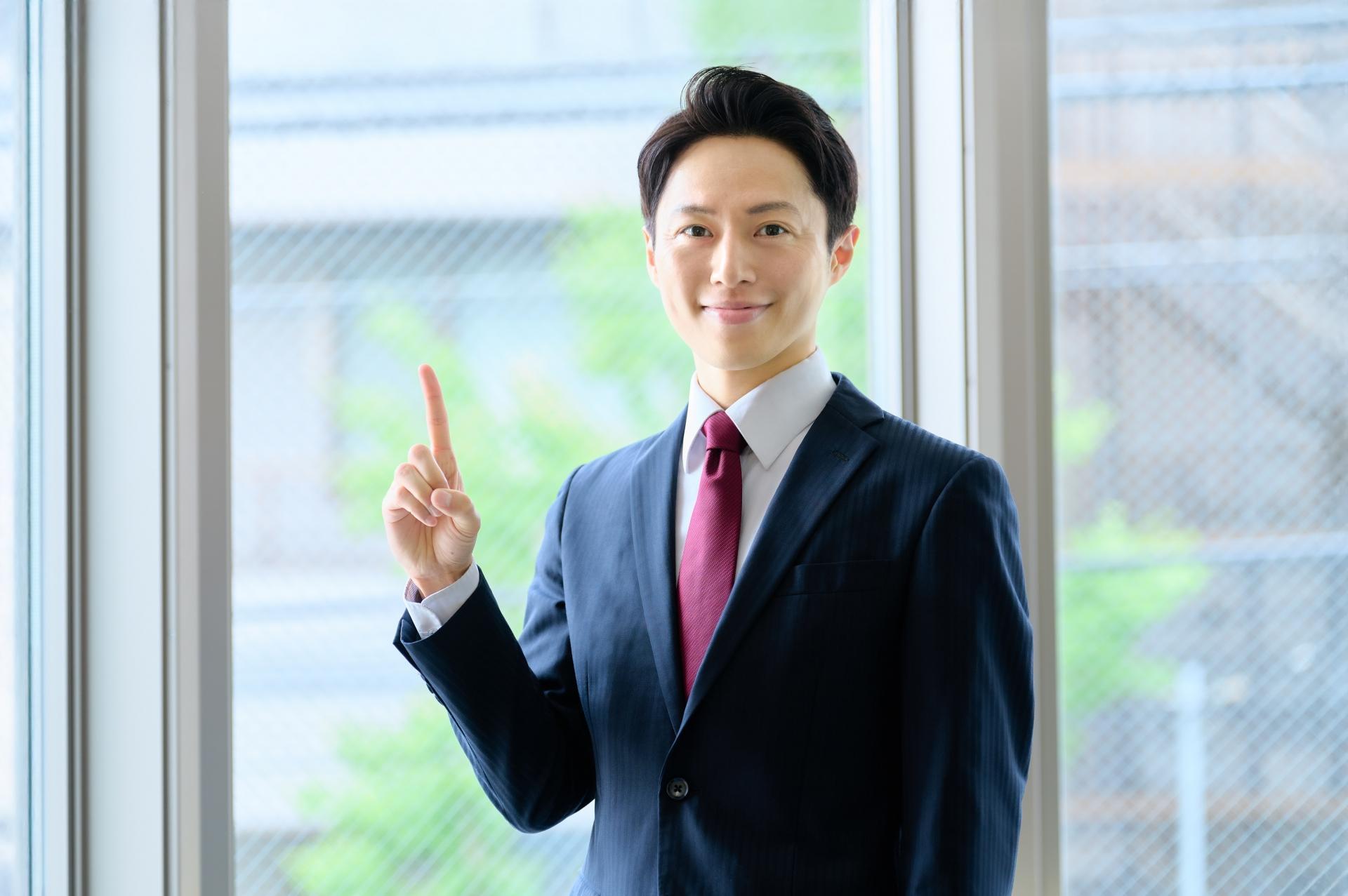 人差し指を立てるビジネスマン 案内する
