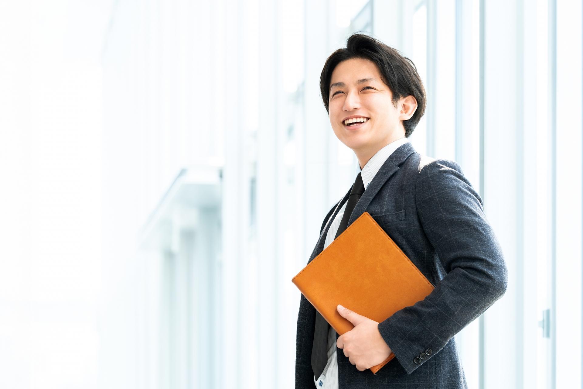 バインダーを持つ笑顔の男性ビジネスマン