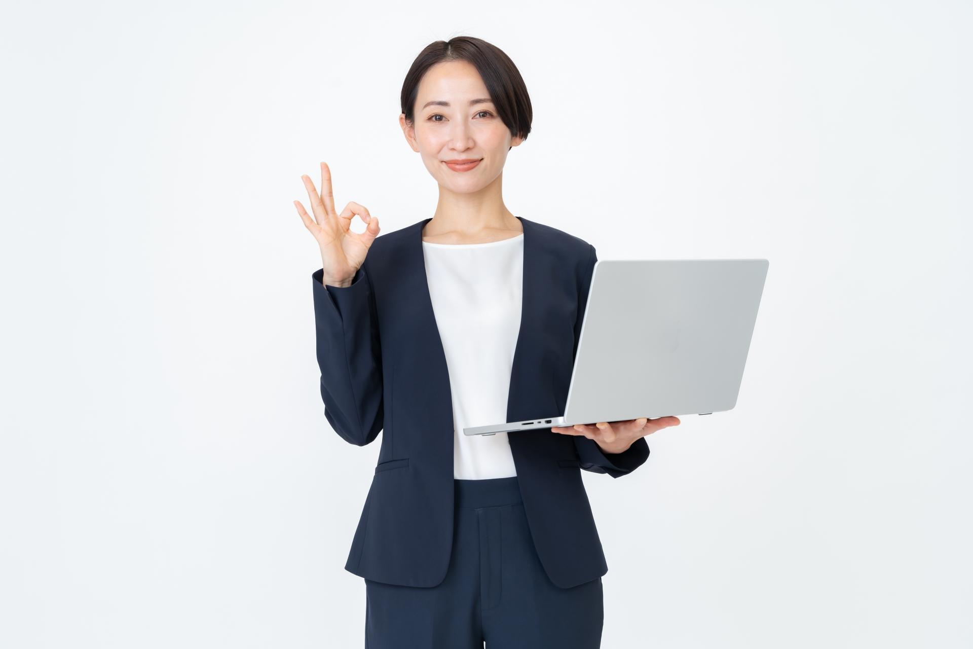 パソコンを持つスーツ姿の女性