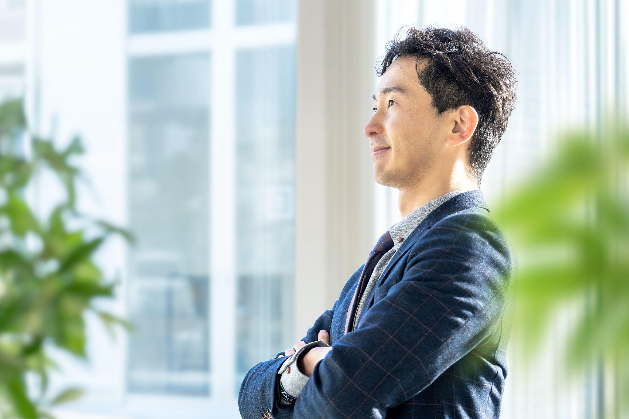 腕組みをする笑顔の男性ビジネスマン