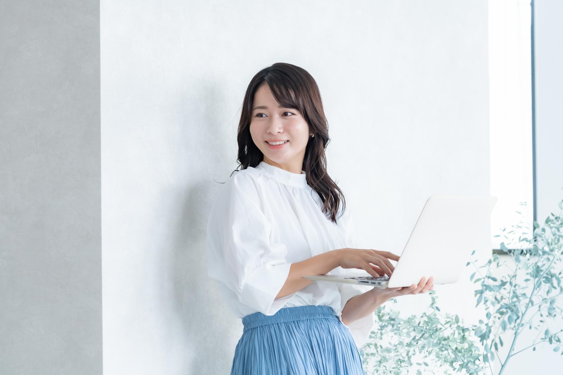 ノートパソコンを持つ若い女性