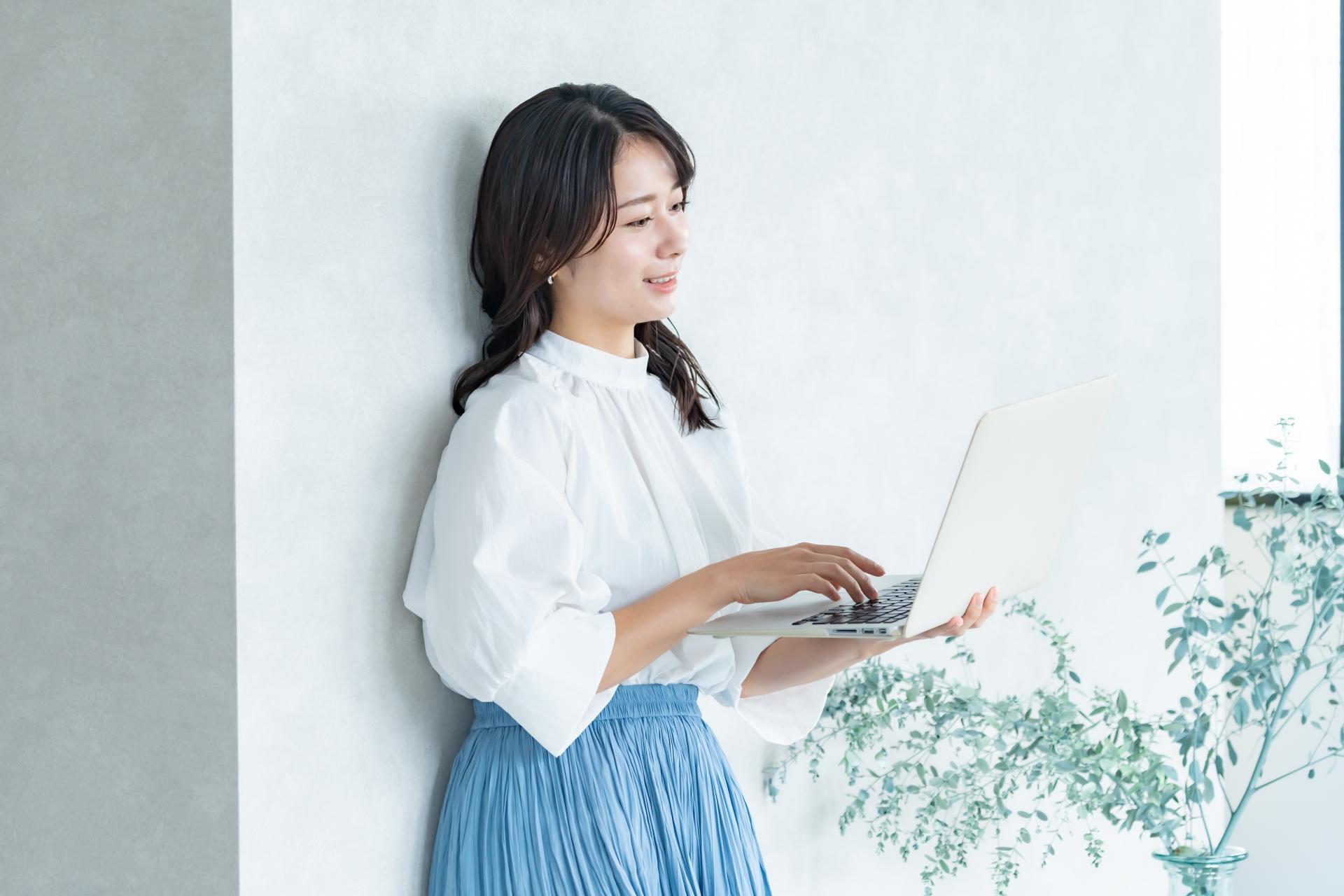 立ちながらパソコン作業をする女性