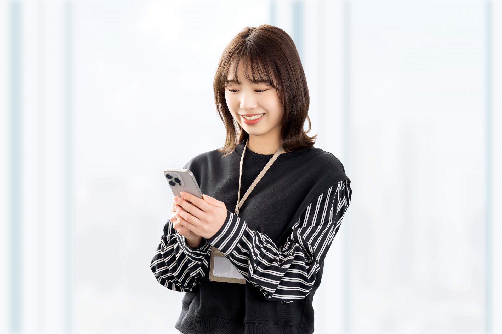 スマホを使う笑顔の女性・ビジネスウーマン