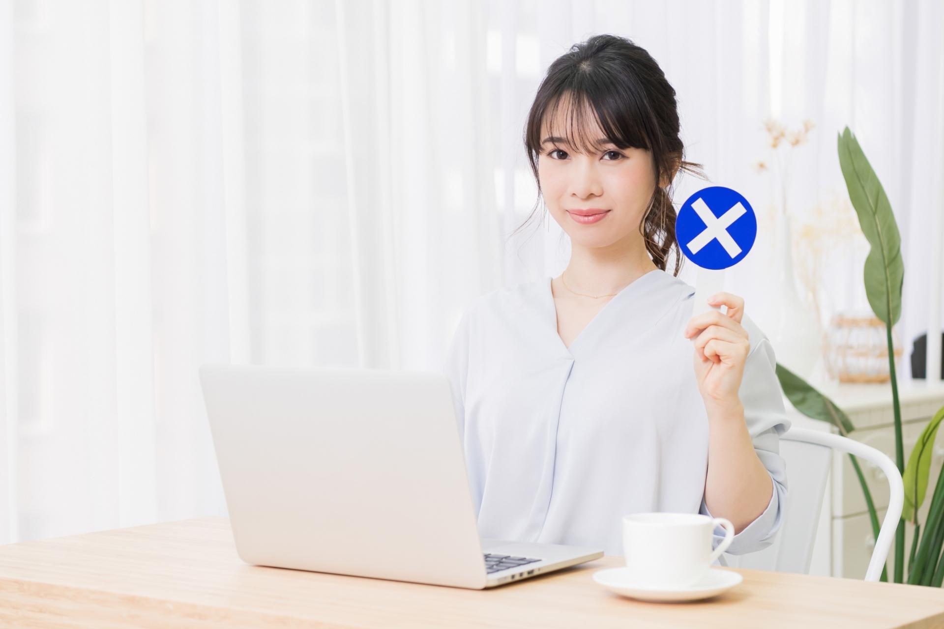 NGのプラカードを持つ若い女性