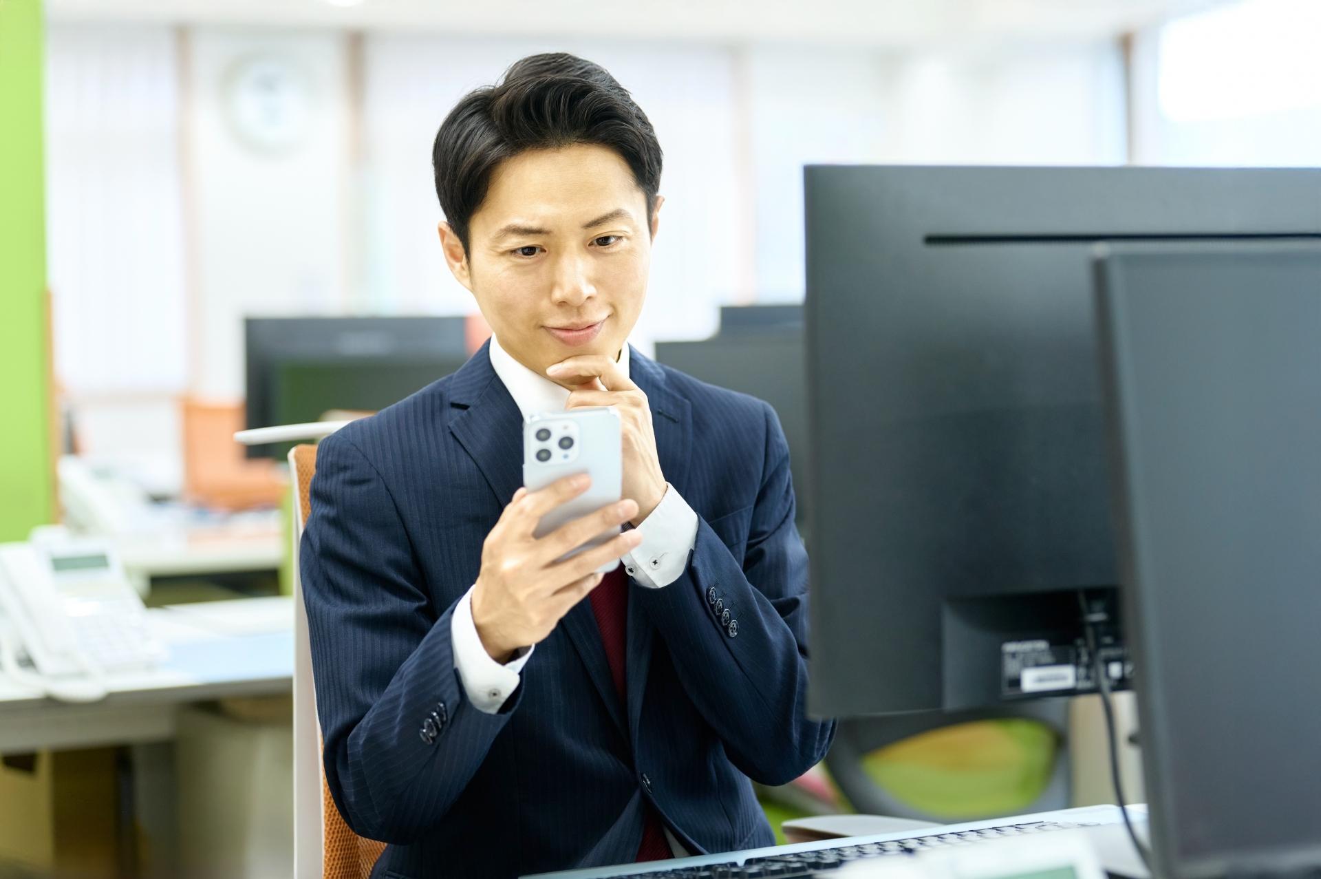 スマホを見るビジネスマン 仕事 会社